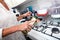 Cropped image of senior woman adding olive oil to saucepan at kitchen counter