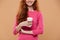 Cropped image of a smiling redhead girl holding coffee cup