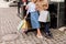 cropped image of stylish couple with shopping bags and paper cups of coffee near piano