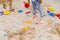 cropped image of two little girls in sandbox with plastic scoops