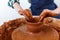 Cropped Image of Unrecognizable Female Ceramics Maker working with Pottery Wheel in Cozy Workshop Makes a Future Vase or