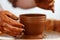 Cropped Image of Unrecognizable Female Ceramics Maker working with Pottery Wheel in Cozy Workshop Makes a Future Vase or