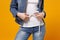 Cropped image of woman in denim clothes isolated on yellow orange background. Proper nutrition losing weight healthy