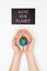 cropped image of woman holding earth model in hands under sign save our planet