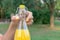 Cropped image of a woman while opening a cold bottle of lemonade in a hot day in the park