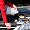 Cropped image of woman pouring windshield washer fluid