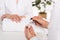 cropped image of woman receiving manicure by beautician with nail polish at table with towel