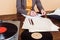 cropped image of woman writing in paper at table with vinyl disc, record player