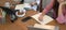 Cropped image of women works together with a computer laptop at the wooden working desk