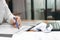 Cropped image of young business woman working with crumpled sheet on the workplace in office