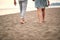 Cropped image of  young couple in casual barefoot walk on sandy beach