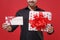 Cropped image of young man in classic black shirt isolated on red wall background. Happy New Year celebration holiday