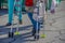 Cropped legs of woman with walker on asphalt street with bag of produce at farmers market