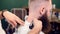 Cropped male barber hands remove hair with brush and shaving neck with electric razor on cropped head of bearded client