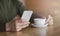 Cropped of man holding smartphone and cup of coffee