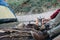 Cropped outdoor image of young man explorer preparing hot beverage in mountains.