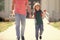 cropped parent leads small boy in first grade. nerd with teacher with book and apple