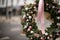 cropped photo of charming wreath of fir branches decorated with glitter balls and plants and bow