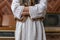 Cropped photo of a female in white national dress who holds her hands in sleeves