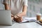 Cropped photo hand of woman writing making list taking notes in notepad working or learning online with laptop at home