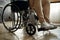 Cropped photo of male office worker in a wheelchair. Disabled man sitting on wheelchair in office. Disability and