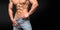 Cropped photo of a male sporty muscular body in jeans posing in studio.