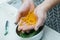 Cropped photo of man wearing apron holding carrot peelings in hands over metal bowl. Recycling, composting, fertilizing.