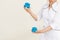 Cropped photo of masseuse doctor woman showing holding blue silicone vacuum cups for massaging on beige background.