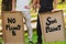 Cropped photo of two men in black and white clothes holding the cardboard posters with inscription to save our planet