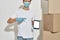 Cropped photo of a young deliveryman pointing in tablet with delivery app