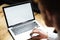 Cropped photo of young man using laptop on wooden table