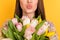 Cropped photo of young woman face send air kiss flowers tulips isolated on shine yellow color background