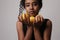 Cropped photo of young woman posing with three parts of lemon on white wall.