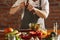 Cropped portrait of male chef, cook preparing vegetable salad in cafe, restaurant kitchen. Concept of a correct, healthy