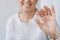 Cropped portrait of smiling elderly woman holding nutritional supplements and a glass of water. Selective focus