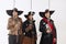 Cropped portrait of thee men in vitage costumes with swords, musketeer and pirate  over white background