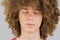 Cropped portrait of a young curly European man with long curly hair and closed eyes close up. very lush male hair. curling hair