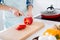 Cropped profile photo of housewife chef arms holding big red pepper bell cutting knife slices enjoy morning cooking