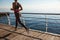 Cropped rear shot of fitness woman jogging on a pier, workout alone