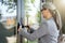 Cropped short of a business woman holding laptop and opening the main door of office building