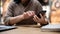 A cropped shot of an Asian woman responding to messages on her smartphone while sitting in a cafe