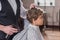 cropped shot of barber combing hair of little kid