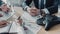 cropped shot of business people having conversation with documents and speakerphone on table