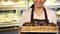 Cropped shot of a cheerful female baker posing with a basket full of croissants