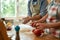 Cropped shot of couple making pizza together. Young man in apron making the dough while woman preparing tomatoes. Hobby