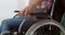 Cropped shot of disabled woman in wheelchair holding boyfriend hand