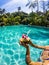 Cropped shot of girl holding coconut cocktail in outdoor swimming pool. Sunny day in tropical country