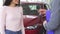 Cropped shot of a happy woman receiving car keys, shaking hands with salesman