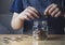 Cropped shot Kid hand putting money coins into clear jar,  Child counting his saved coins, Childhood hand holding coin, Children