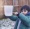 Cropped shot of Littl boy holding measuring jug pointing at level of rain collected in garden. 6 year old child measuring rainfall